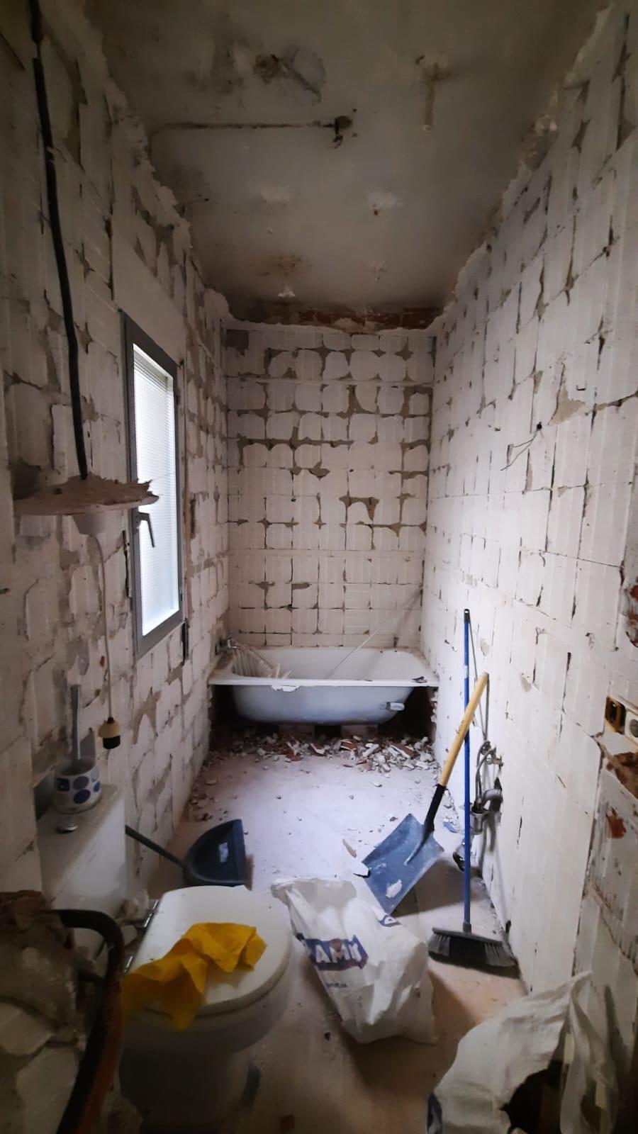 Baño antiguo demolido con la bañera y los tabiques al descubierto