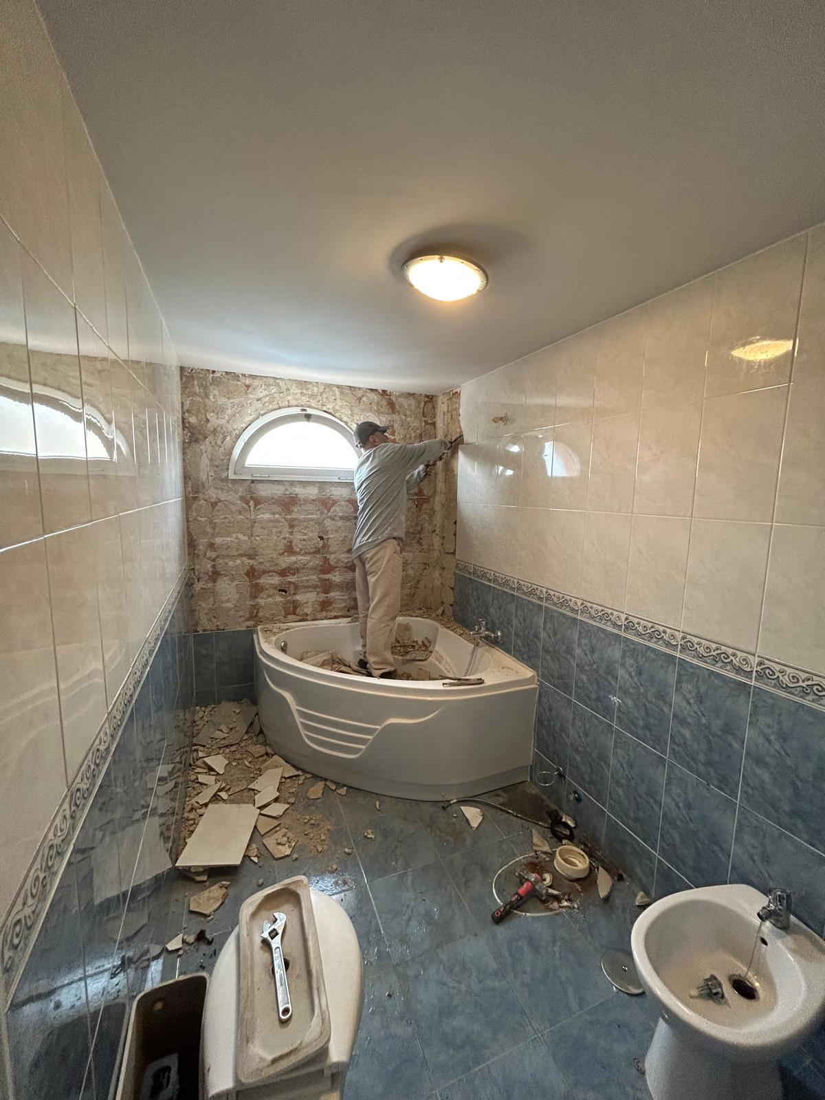Demolición del alicatado y la bañera antes de la reforma del baño